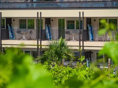 an apartment building with chairs and tables on the balconies at Garni Hotel Sonnleitenhof in Caldaro