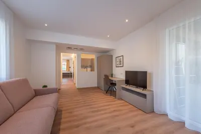 a living room with a couch and a desk and a television at Garni Hotel Sonnleitenhof in Caldaro
