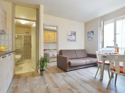 a kitchen and living room with a couch and a table at Apartment Apt 20 by Interhome in Alba di Canazei