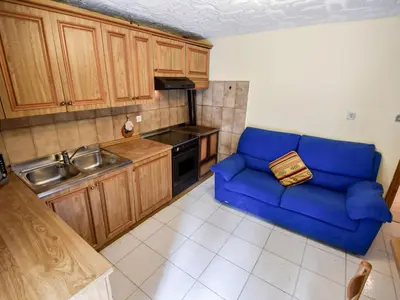 a blue couch in a kitchen with a sink at Apartment La Busa-4 by Interhome in Alleghe