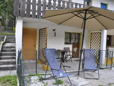 a patio with two chairs and an umbrella at Apartment La Busa-4 by Interhome in Alleghe