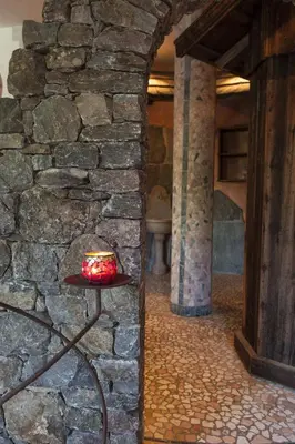 a table in front of a stone wall with a cake on it at Landhotel Tharerwirt in Valdaora