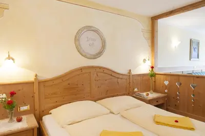 a bedroom with a bed and a clock on the wall at Landhotel Tharerwirt in Valdaora