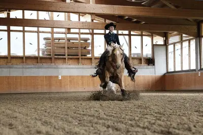 a woman riding a horse in a stable at Landhotel Tharerwirt in Valdaora