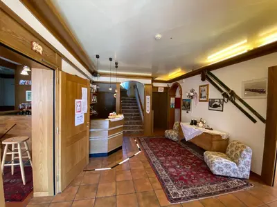 a living room with a couch and a staircase at Hotel Camoscio in Rocca Pietore