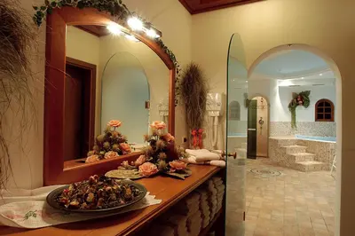 a bathroom with a large mirror and a bowl of food at Hotel Camoscio in Rocca Pietore