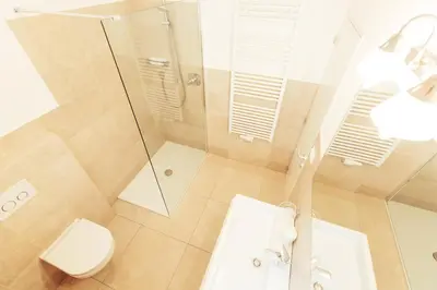 a bathroom with a shower and a toilet and a sink at Amplatz 1523 - B&B and Suites in Montagna