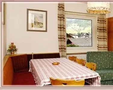 a dining room with a table and a window at Garni Sayonara in Selva di Val Gardena