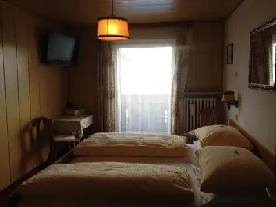 two beds in a room with a window at Garni Sayonara in Selva di Val Gardena