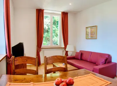 a living room with a couch and a table at Apartments Waldquell in Collalbo