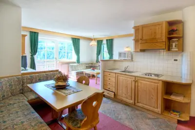 a kitchen and living room with a table and a couch at Residenz am Kaiserweg in Longomoso
