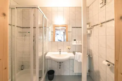 a white bathroom with a sink and a shower at Residenz am Kaiserweg in Longomoso