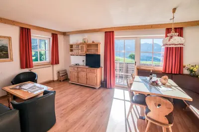a living room with a dining room table and a kitchen at Residenz am Kaiserweg in Longomoso