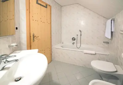 a bathroom with a sink and a tub and a toilet at Residenz am Kaiserweg in Longomoso
