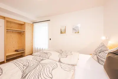a bedroom with two beds and a window at Appartamenti Elbrus in Santa Cristina in Val Gardena