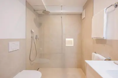 a bathroom with a shower with a toilet and a sink at Appartamenti Elbrus in Santa Cristina in Val Gardena
