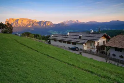 a house on a hill with mountains in the background at Gasthaus Bad Siess in Longomoso