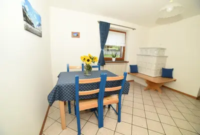 a dining room with a blue table and chairs at Cesa Mandi e Miky in Canazei