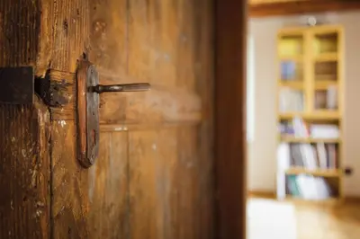 a wooden door with a metal handle in a room at LA PITA in La Valle