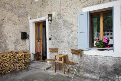 a house with two chairs and a table and a window at LA PITA in La Valle