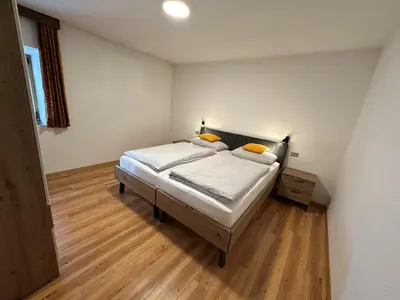 a bedroom with a bed with white sheets and yellow pillows at Ciasa Alfri in La Villa