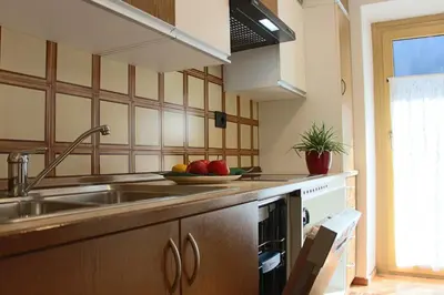 a kitchen with a sink and a bowl of fruit on the counter at Ciasa Alfri in La Villa