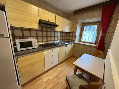 a small kitchen with a microwave and a table at Ciasa Alfri in La Villa