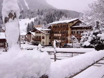 a resort in the mountains covered in snow at Hotel Patrizia Dolomites Glamour in Moena
