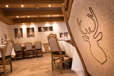 a restaurant with a table with a deer drawn on the wall at Hotel Patrizia Dolomites Glamour in Moena