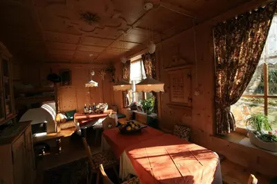 a room with a kitchen with a table and a window at B&B Ciasa Weber in Moena