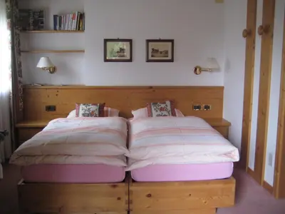 a bedroom with a bed with a wooden headboard at B&B Ciasa Weber in Moena