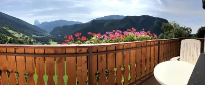 a wooden fence with a bench and flowers on it at Nature Residence Telfnerhof in Laion
