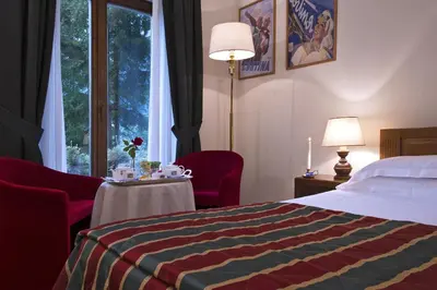 a hotel room with a bed and a window at Boutique Hotel Villa Blu Cortina D'Ampezzo in Cortina dʼAmpezzo