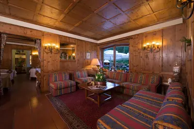 a living room with couches and a table at Boutique Hotel Villa Blu Cortina D'Ampezzo in Cortina dʼAmpezzo