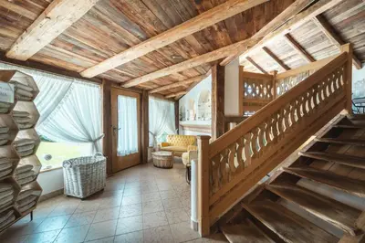 a room with a balcony with chairs and windows at Historic Hotel Alte Goste in Valdaora