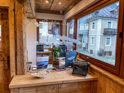 an office with a desk with a computer and a window at Hotel da Beppe Sello in Cortina dʼAmpezzo