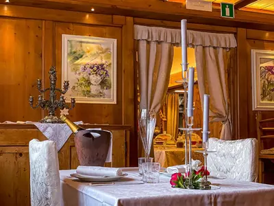 a dining room with a table with a white table cloth at Hotel da Beppe Sello in Cortina dʼAmpezzo