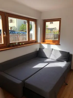 a bed sitting in a room with two windows at Apartment Himmelreich in Brunico
