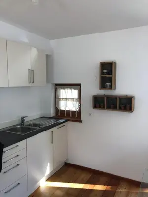 a kitchen with white cabinets and a sink and a window at Apartment Himmelreich in Brunico