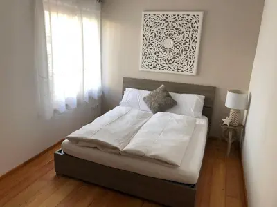 a bedroom with a bed with white sheets and a window at Apartment Himmelreich in Brunico