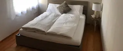 a bed with white sheets and pillows on it at Apartment Himmelreich in Brunico