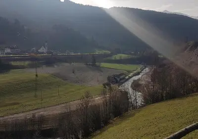 a view of a river in a field with a train at Temblhof in Vipiteno