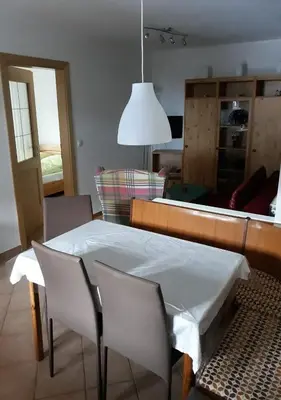 a living room with a table and chairs and a mirror at Temblhof in Vipiteno