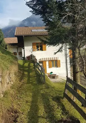 a white house with a fence in front of it at Temblhof in Vipiteno