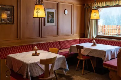 a restaurant with two tables and chairs and a window at Garni Juri in La Villa