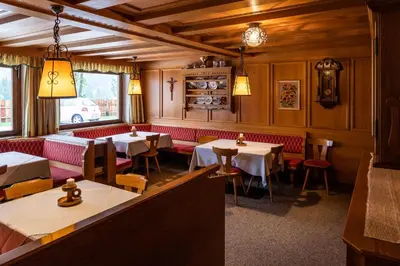 a restaurant with tables and chairs in a room at Garni Juri in La Villa