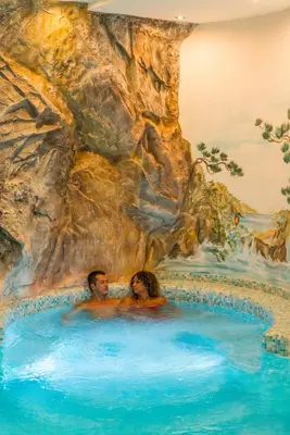 a painting of two people in a swimming pool at La Montanina Hotel in Val di Non in Malosco