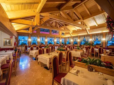a restaurant with tables and chairs in a room at Hotel Barance in Alleghe