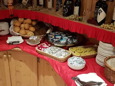 a table with baskets of food on a red table cloth at Hotel Barance in Alleghe