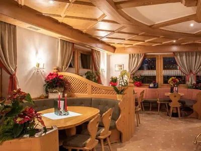 a restaurant with couches and tables and chairs at Hotel Barance in Alleghe